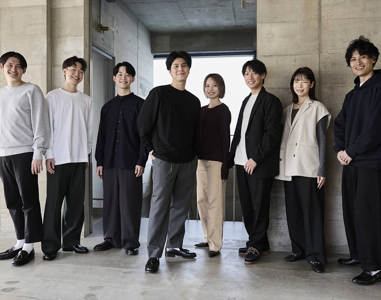 パソコンを前に話している男性たちを上から撮った写真